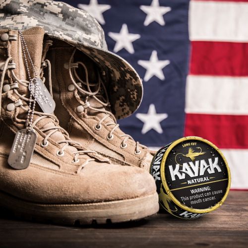 Can of Kayak Natural in front of military boots with dog tag and US flag in background